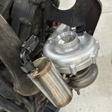 Turbocharger oil drain canister installed on engine fitted with original exhaust manifolds